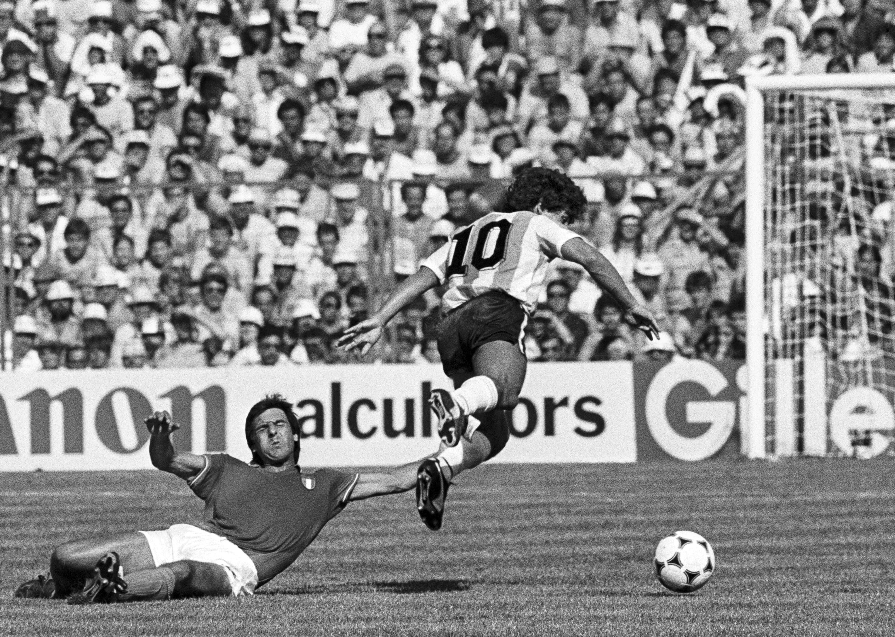 Barcelona, 29/06/1982. El jugador argentino Diego Armando Maradona sufre la falta cometida por el defensa italiano Gaetano Scirea, durante el partido disputado por las selecciones de Italia y Argentina, correspondiente a la segunda fase, grupo C, del Campeonato de Mundo de Fútbol España 82, que ha finalizado con el triunfo del equipo italiano por 2 a 1 (Archivo EFE)