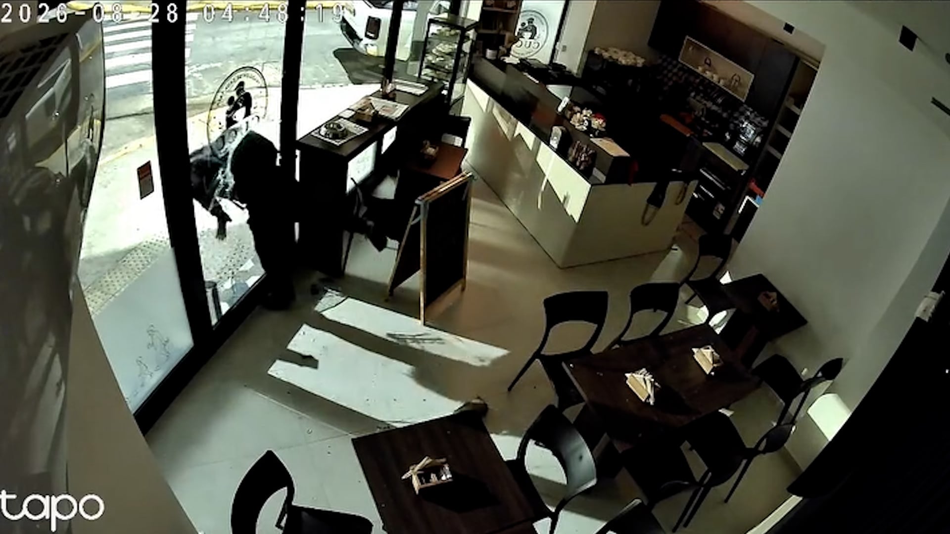 Una cámara de seguridad graba el momento en que una persona rompe la puerta de vidrio de una cafetería para robar en el barrio de Villa Devoto.