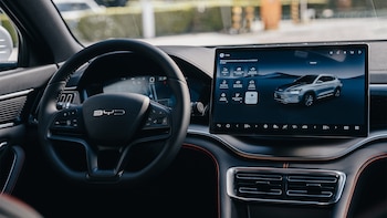 Volante de cuero, pantalla táctil digital, consola central, salidas de aire acondicionado y panel de control en el interior de un automóvil