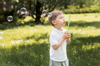 Un niño jugando con pompas