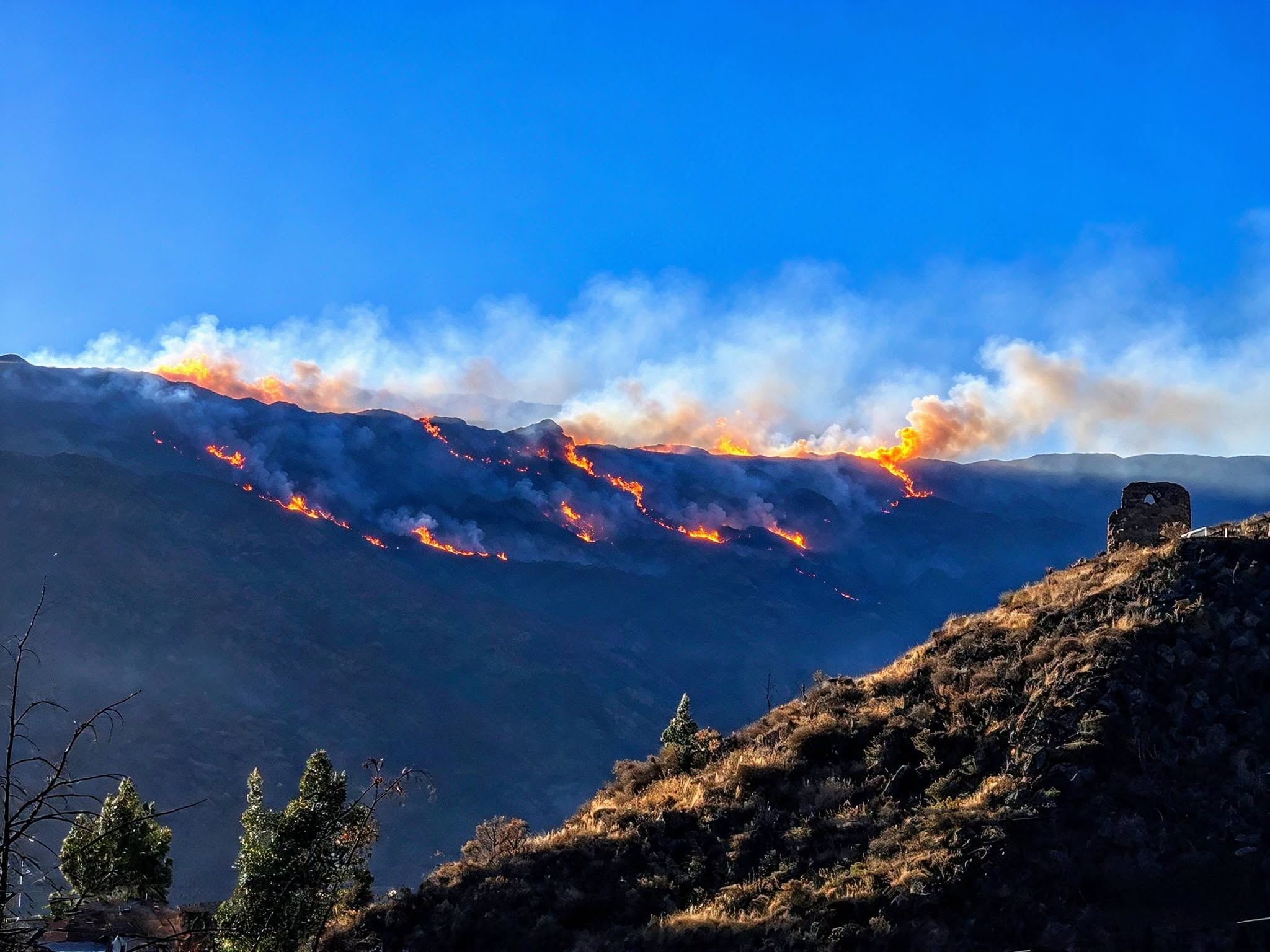 Un incendio forestal en las montañas de Coporaque, Caylloma, genera columnas de humo y fuego que amenazan el ecosistema del Valle del Colca en Arequipa. (Foto: Impacto PE / Facebook)