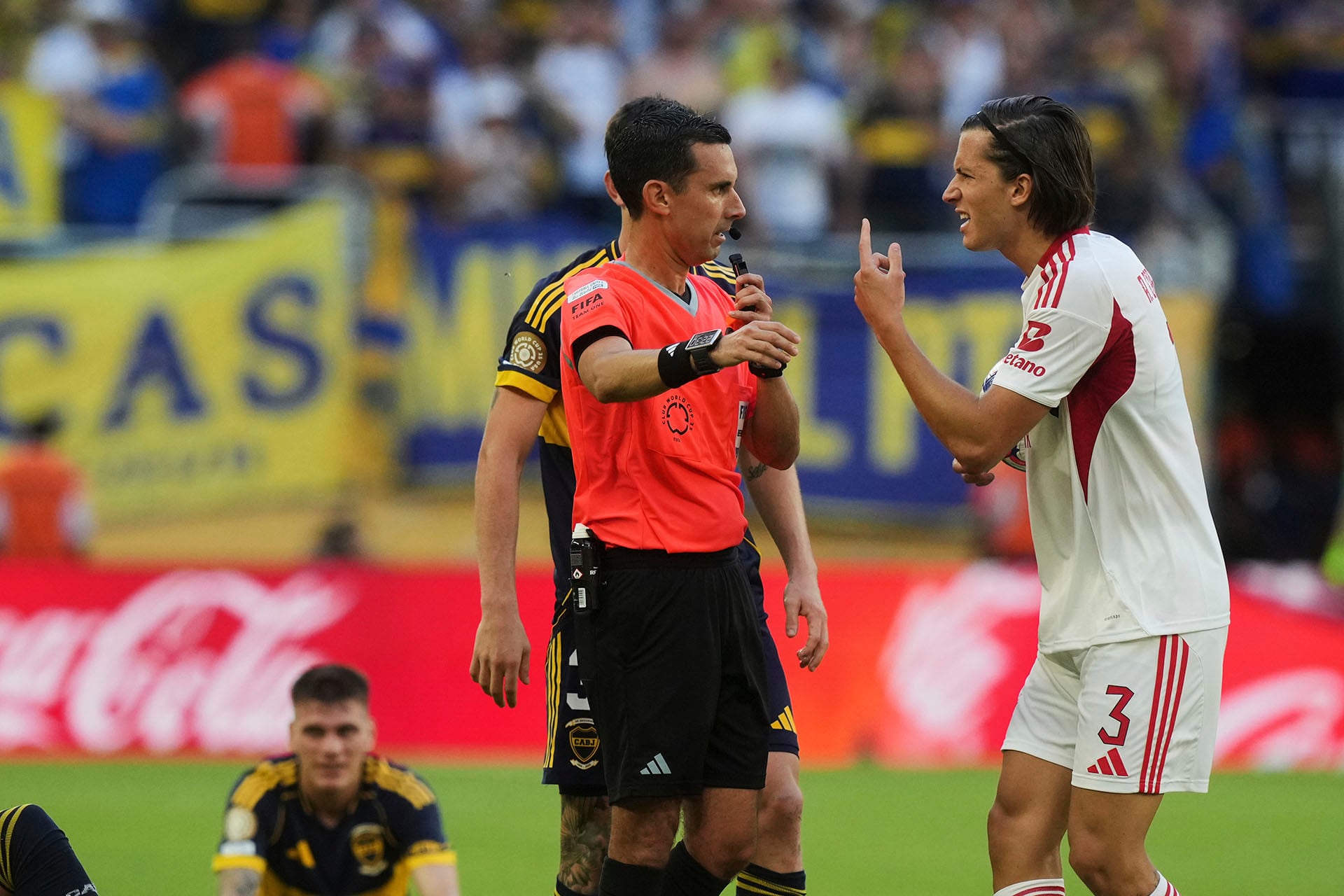 Benfica's Alvaro Carreras, right, pleads with referee CÈsar Arturo Ramos Palazuelos after he was giving yellow card during the Club World Cup group C soccer match between Boca Juniors and Benfica in Miami Gardens, Fla., Monday, June 16, 2025. (AP Photo/Marta Lavandier)