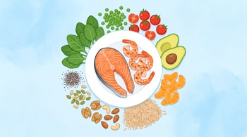 Plato blanco con salmón y camarones. Rodean el plato: espinacas, arvejas, tomates cherry, rodajas de palta, gajos de mandarina, arroz integral, nueces y semillas.
