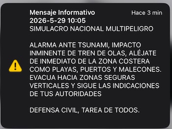 Pantalla de teléfono móvil mostrando un mensaje de alerta de emergencia de SISMATE en español, indicando "SIMULACRO NACIONAL MULTIPELIGRO" y una alarma de tsunami