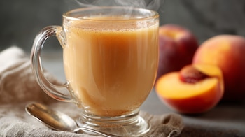 Taza de atole de durazno caliente con color melocotón y textura cremosa. — (Imagen Ilustrativa Infobae)