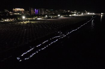 Miles de personas iluminan una playa de arena italiana para romper un récord mundial