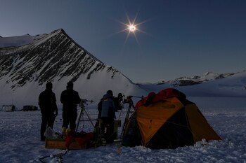 Persons observe a solar eclipse