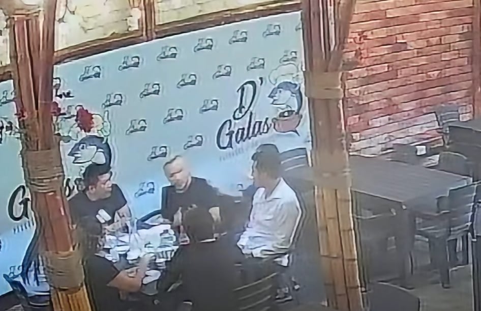 El estilista Carlos Cacho conversa con varias personas en un restaurante de Trujillo tras ser acusado de agredir a un menor de edad.