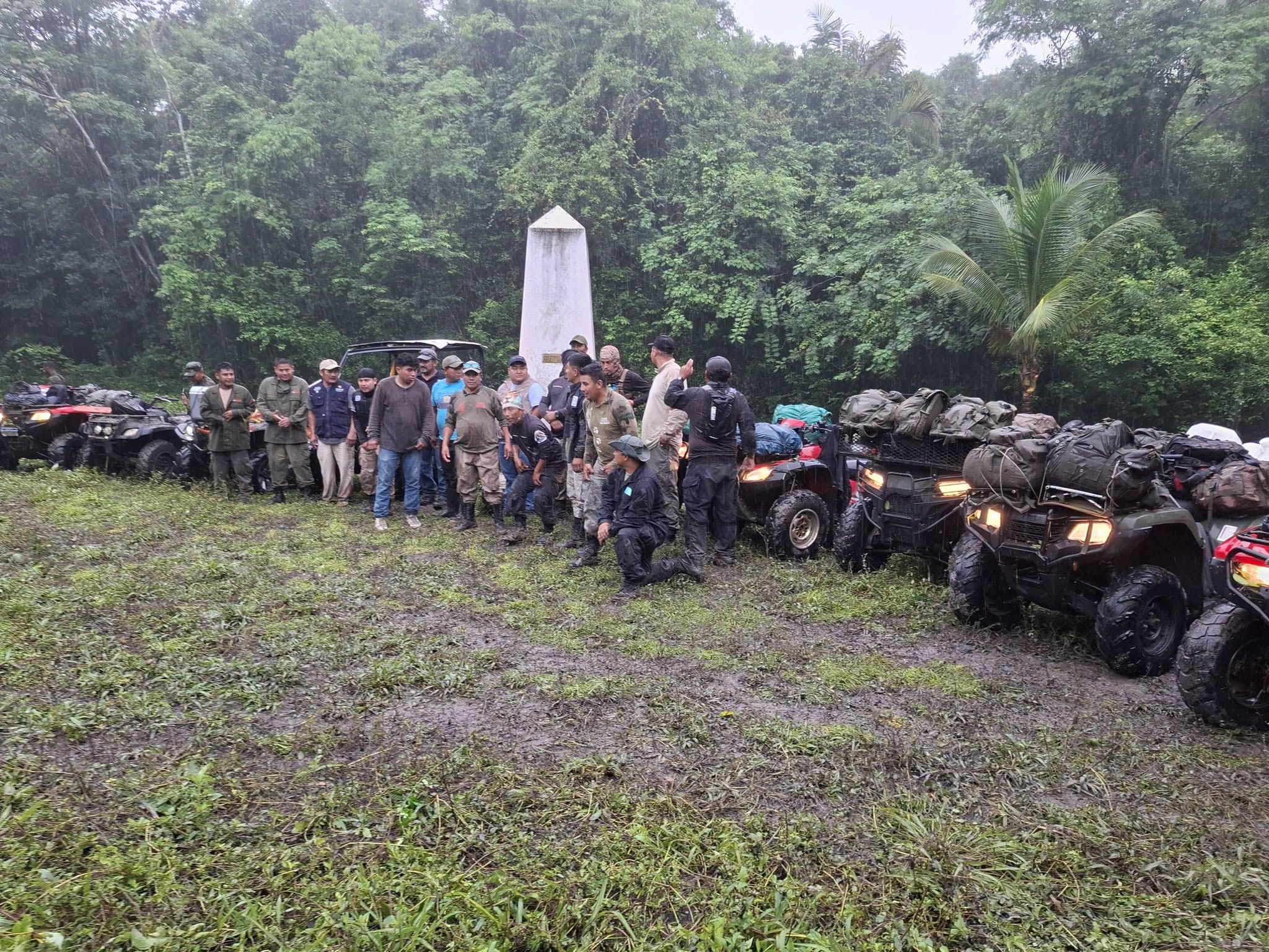 Un grupo de personas realiza una parada junto a un obelisco en una zona selvática con varios vehículos todo terreno. (Francisco Asturias )