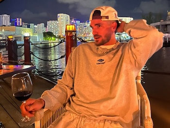 Rodrigo De Paul, en una noche en lo que parece ser Miami: vino tinto, skyline y buzo Balenciaga