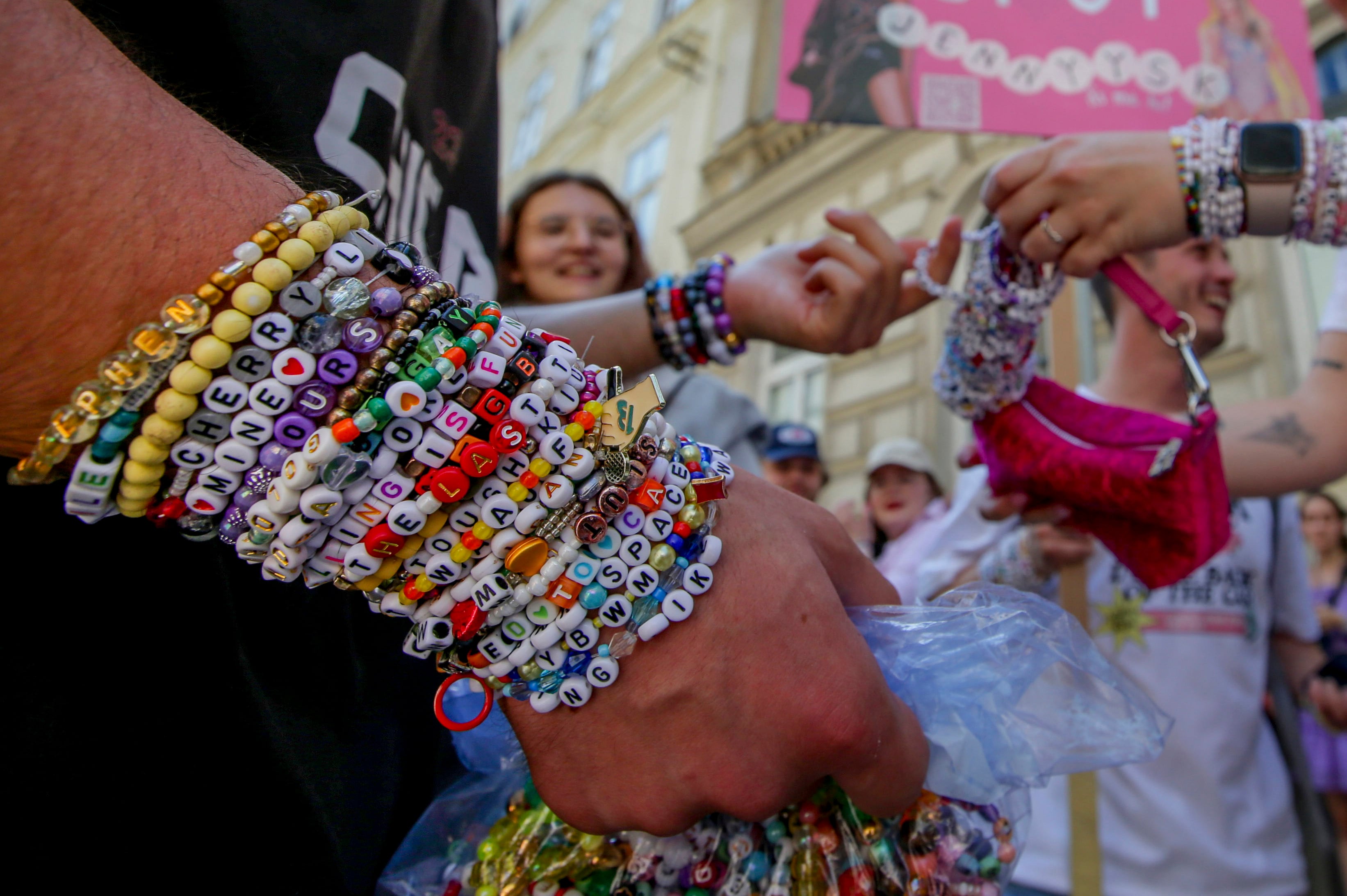 Swifties intercambian pulseras en el centro de Viena el jueves 8 de agosto de 2024. (AP Foto/Heinz-Peter Bader)