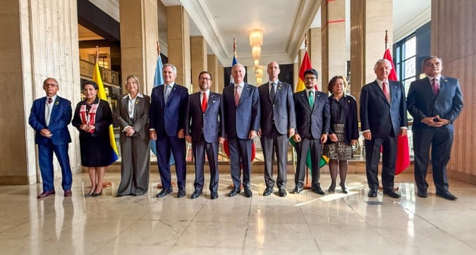 Delegaciones oficiales de Chile, Perú, Argentina, Bolivia y Ecuador posan juntas durante un encuentro de alto nivel, con banderas nacionales visibles en el fondo de un salón formal