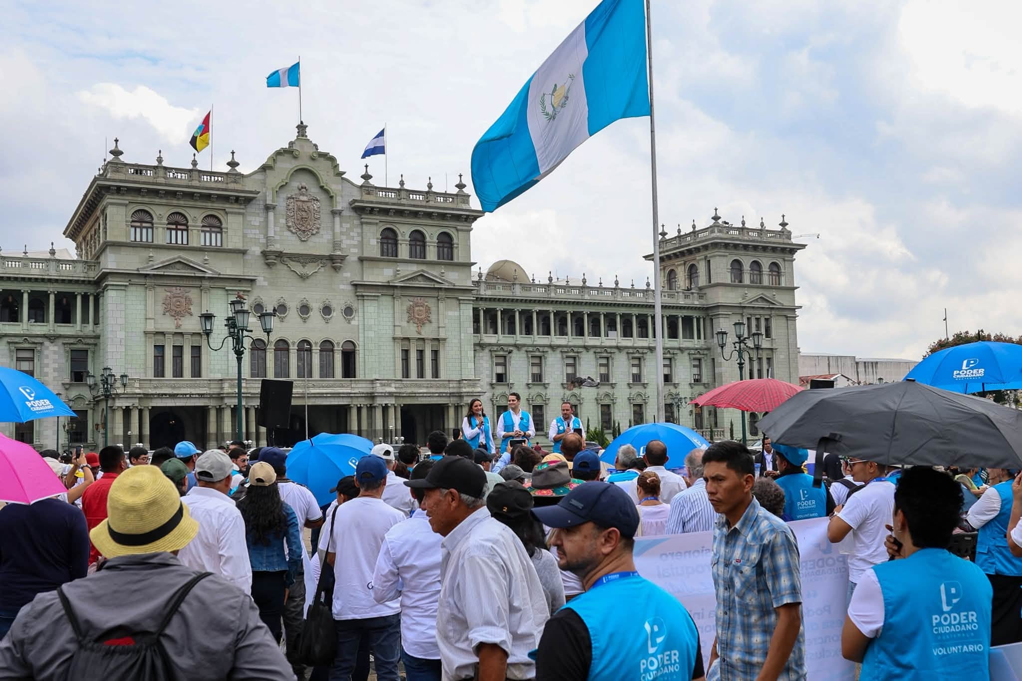 Una multitud con distintivos de la organización Poder Ciudadano participa en una concentración política frente al Palacio Nacional de la Cultura en Ciudad de Guatemala. (Poder Ciudadano GT)
