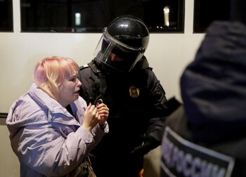 Una manifestante reacciona mientras es