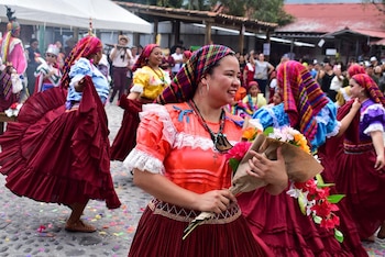Visitantes nacionales y extranjeros observan las danzas típicas en la plaza central de Panchimalco.
