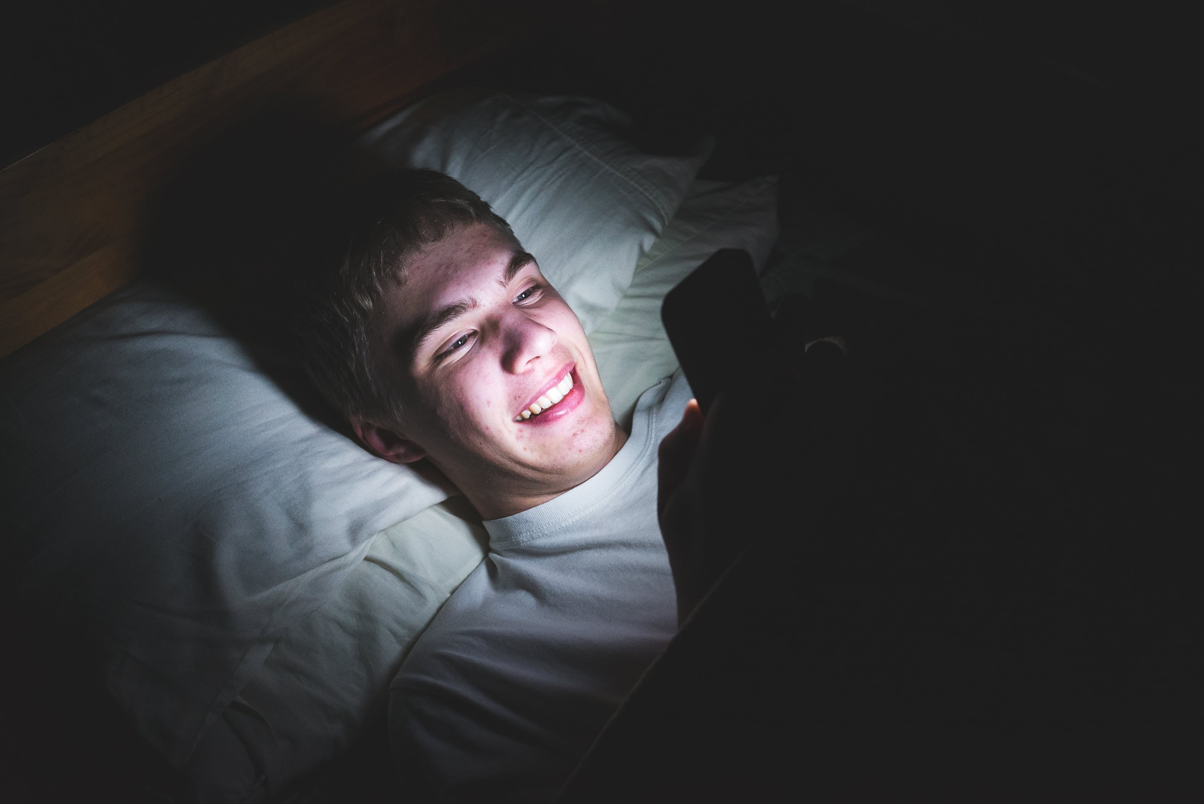 Un joven utilizando su móvil en la noche (Shutterstock)