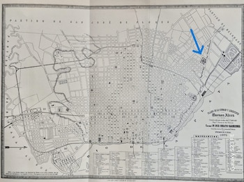 Plano antiguo de Buenos Aires en blanco y negro con división en manzanas, referencias en la parte inferior y una flecha azul dibujada