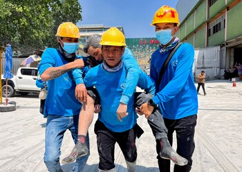 Workers carry an injured person near the site of a collapsed building after a strong earthquake struck central Myanmar on Friday, earthquake monitoring services said, which affected Bangkok as well with hundreds of people pouring out of buildings in the Thai capital in panic after the tremors, in Bangkok, Thailand, March 28, 2025. REUTERS/Ann Wang TPX IMAGES OF THE DAY