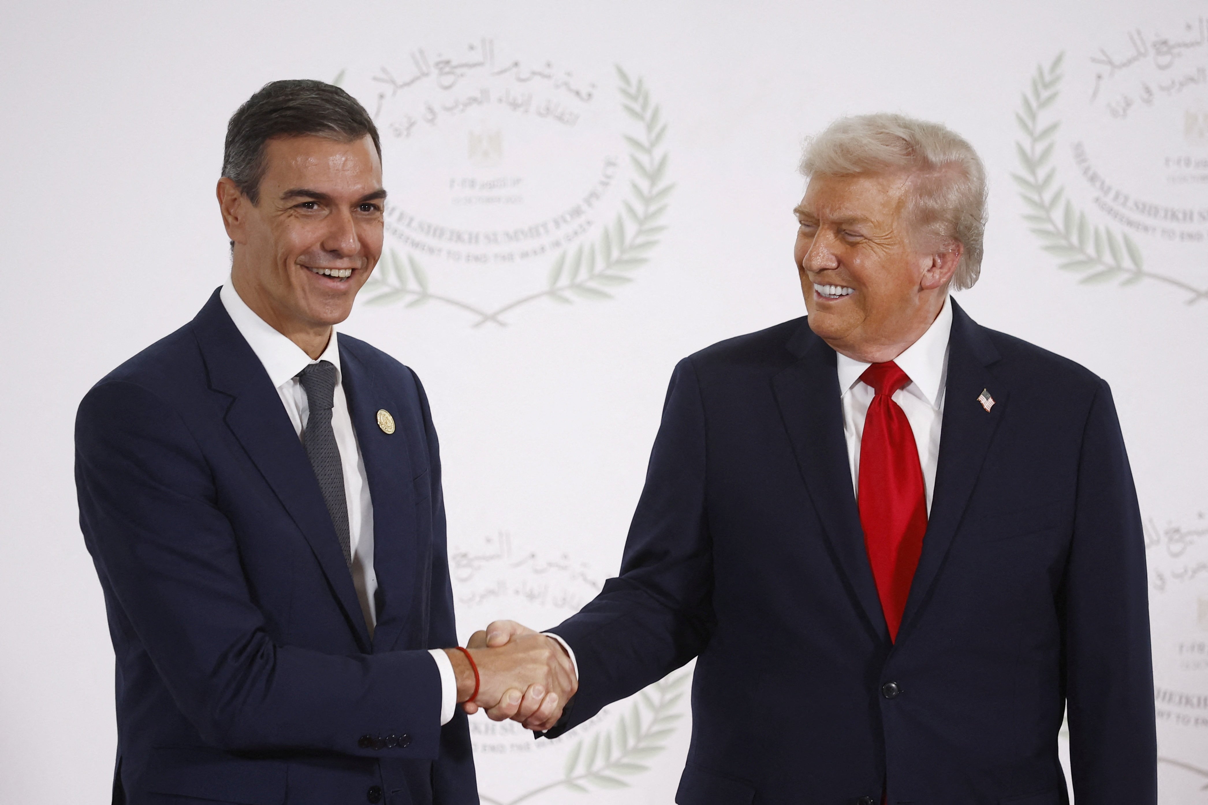 El presidente del Gobierno español, Pedro Sánchez, y el presidente de EEUU, Donald Trump, se dan la mano mientras posan para una foto en una cumbre de líderes mundiales sobre el fin de la guerra de Gaza, en el marco de un acuerdo de alto el fuego y un intercambio de prisioneros, mediado por Estados Unidos, entre Israel y Hamás, en Sharm el-Sheij, Egipto. 13 de octubre de 2025. Yoan Valat/Pool vía REUTERS