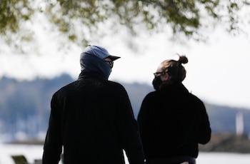 Dos personas usan máscaras al