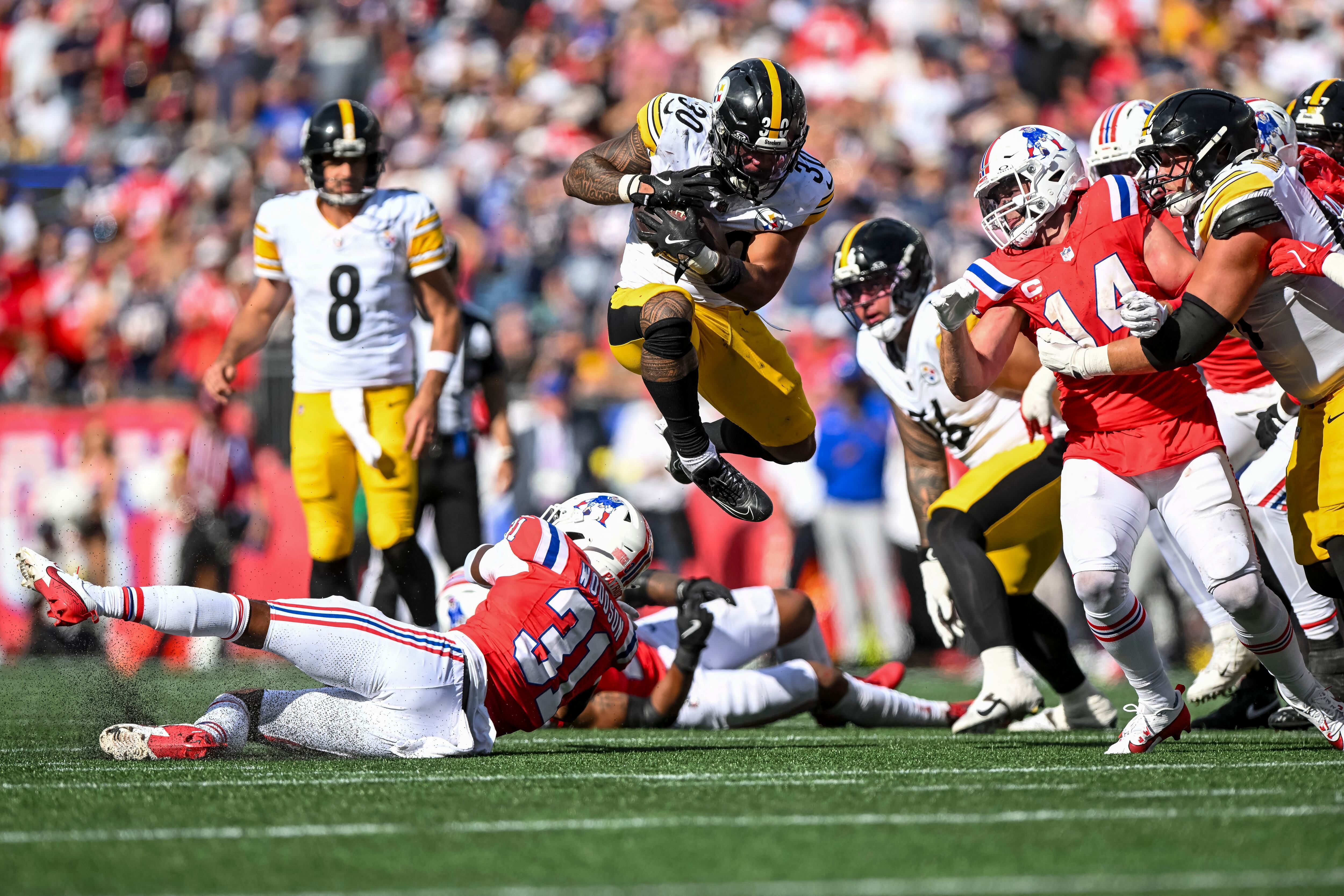El corredor de los Pittsburgh Steelers, Jaylen Warren, salta sobre el safety de los New England Patriots, Craig Woodson, durante el cuarto cuarto en el Gillette Stadium (Brian Fluharty-Imagn Images vía Reuters)