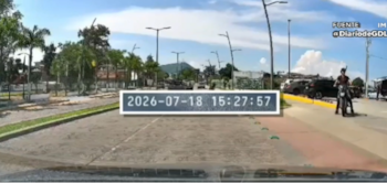 Un automóvil de plataforma digital circula por una avenida del centro de Chapala, Jalisco, seguido de cerca por varias motocicletas y un auto gris. Crédito: Especial
