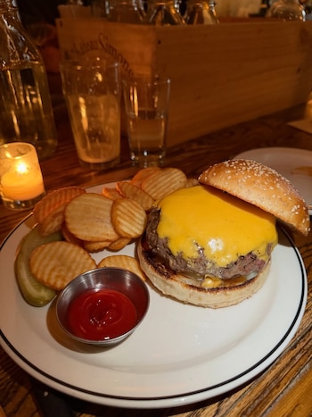 Dry-Aged Red Hook Tavern Burger de carne madurada, queso americano y cebolla blanca, enfocada en realzar el sabor esencial de la carne