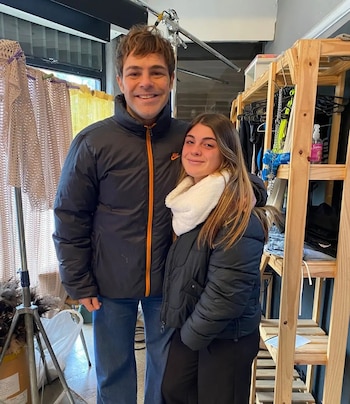 Peter Lanzani, un hombre de cabello castaño y chaqueta negra, posa sonriente con una mujer joven de cabello largo y bufanda blanca