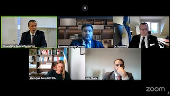 Pantallazo de videollamada con seis participantes en recuadros individuales. Hombres y una mujer, algunos con traje, con etiquetas de sus nombres y roles