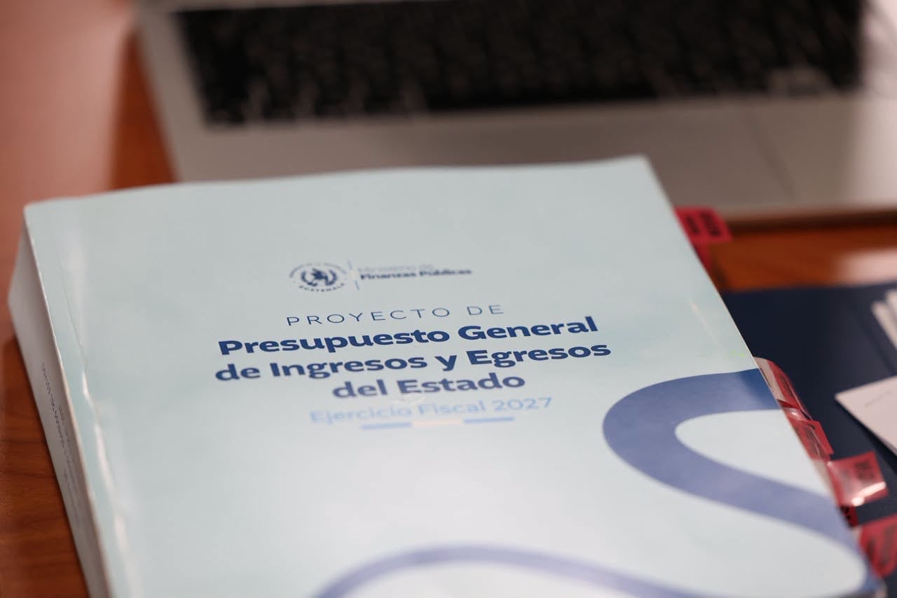 Un documento del Proyecto de Presupuesto General de Ingresos y Egresos del Estado reposa sobre un escritorio junto a una computadora portátil. (Congreso de la República de Guatemala)
