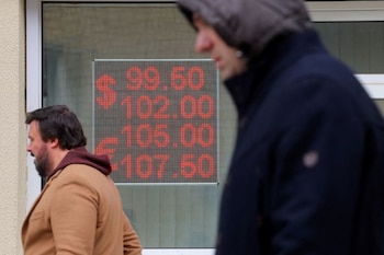 Peatones junto a un tablero electrónico que muestra los tipos de cambio del dólar estadounidense y el euro frente al rublo ruso en una calle de Moscú (REUTERS/Evgenia Novozhenina)