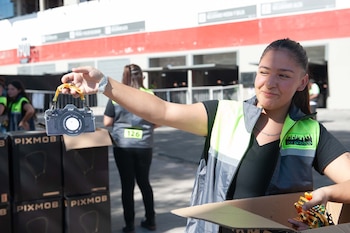 El staff distribuye colgantes identificatorios