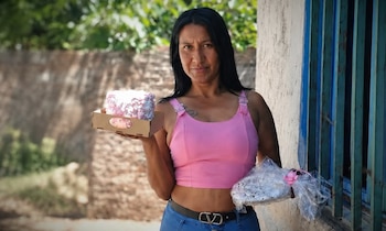 Cinta plástica con la palabra peligro extendida sobre un suelo de tierra junto a vegetación y árboles al fondo