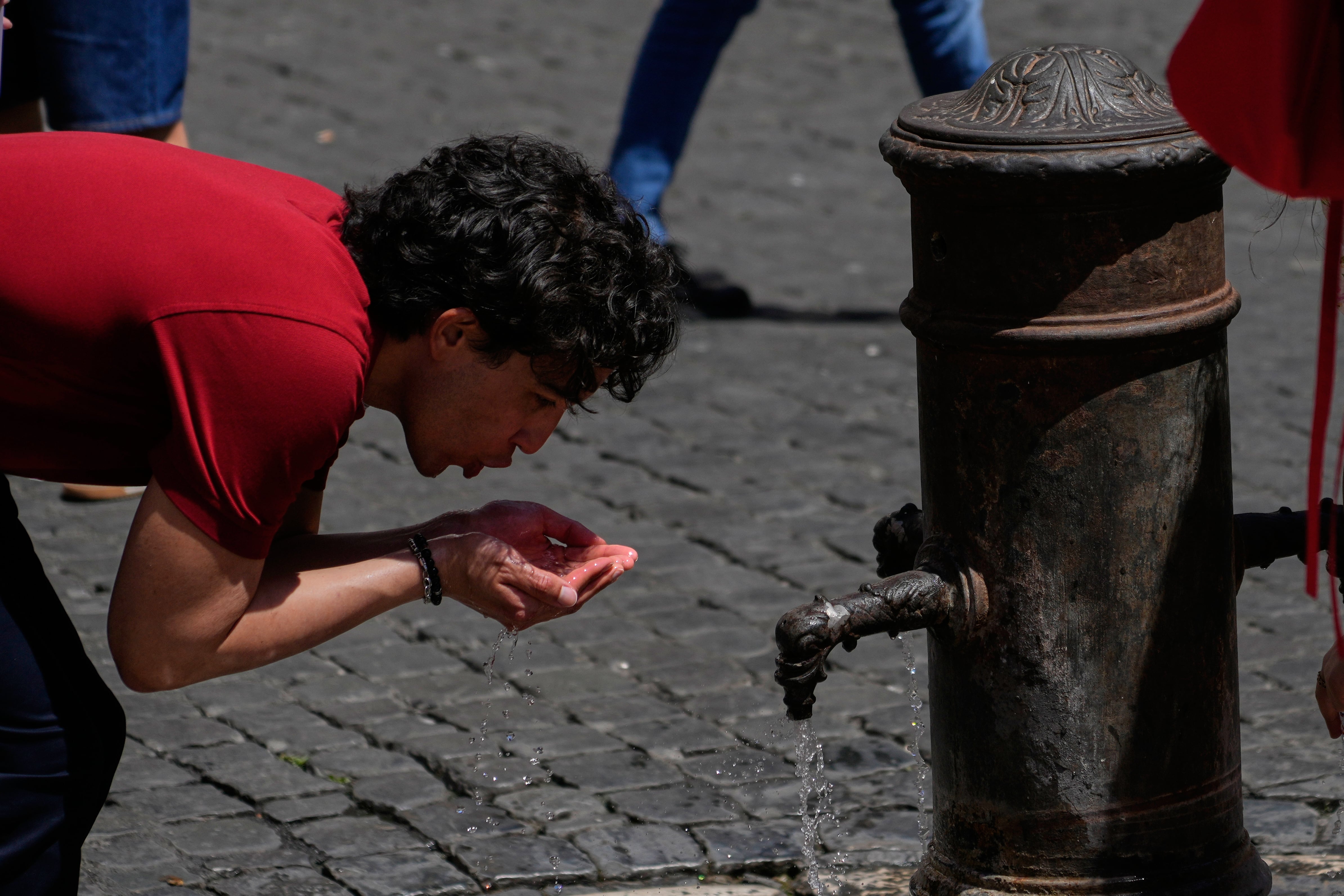 Un hombre se hidrata en una fuente del centro de Roma, donde las temperaturas superaron los 32 °C en plena primavera, mientras Italia enfrenta alertas de calor y restricciones al trabajo al aire libre por el domo de calor que azota Europa. (AP Photo/Gregorio Borgia)
