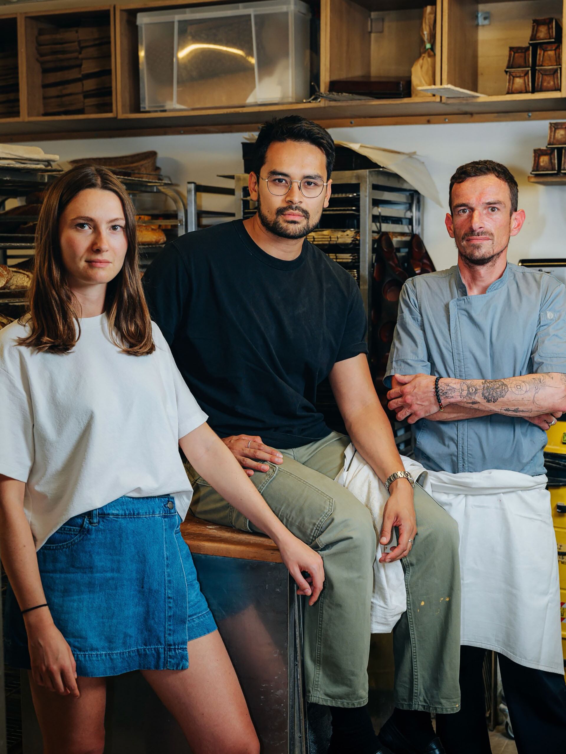 El equipo de la panadería posa para la cámara en el interior de su establecimiento, mostrando el ambiente de trabajo y los productos horneados al fondo (@guillotinebakery)