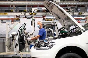 FOTO DE ARCHIVO: Un trabajador usando mascarilla en la línea de montaje de Volkswagen en Wolfsburgo, Alemania. 27 de abril, 2020. Swen Pfoertner/Pool via REUTERS/Archivo