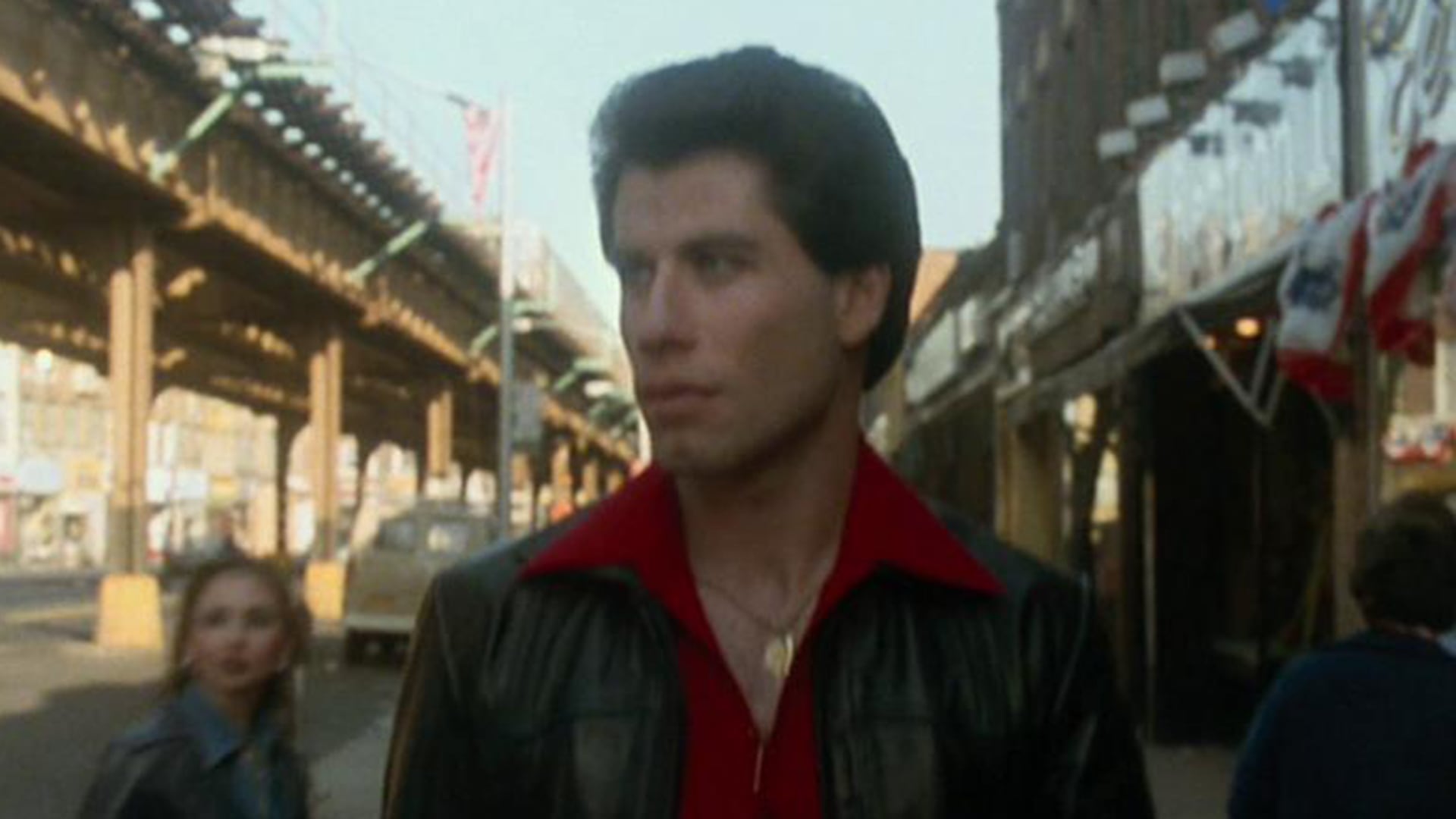John Travolta en su papel de Tony Manero, camina por las calles de Nueva York en una escena inolvidable de la película 'Fiebre de sábado por la noche'. (Captura de video)