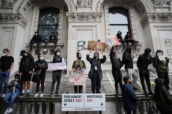 Manifestantes sostienen carteles en Whitehall