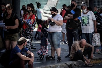 Varias personas hacen fila para