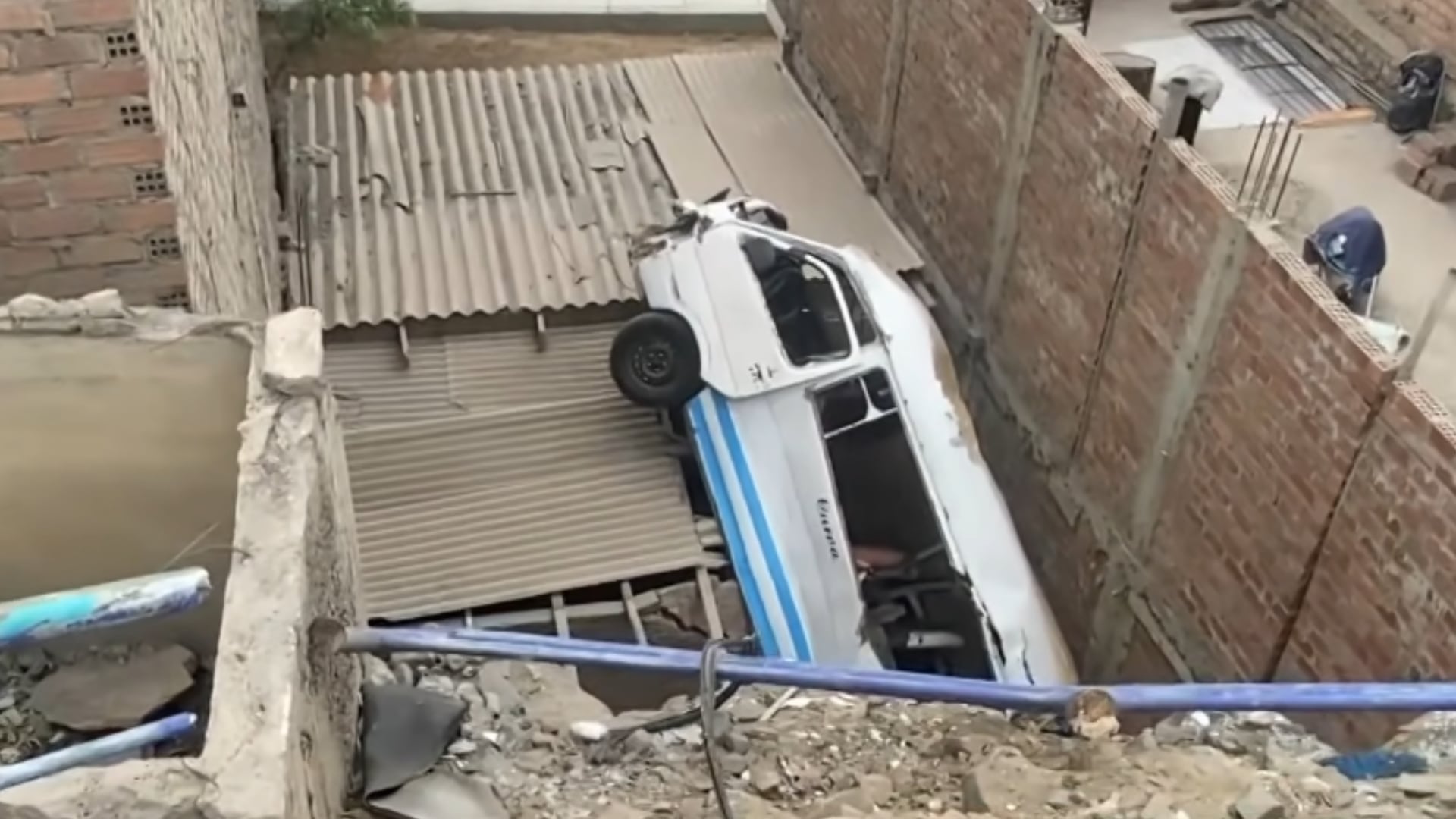 Una combi de transporte público permanece incrustada en el techo de una vivienda en Chorrillos tras descender por una pendiente. (Captura: 24 Horasa / Panamericana Televisión)