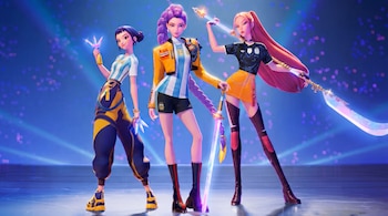 Tres guerreras K-Pop animadas posan en un escenario azul. Llevan camisetas de la selección argentina y vestimenta con colores amarillo y azul. Sostienen armas brillantes.