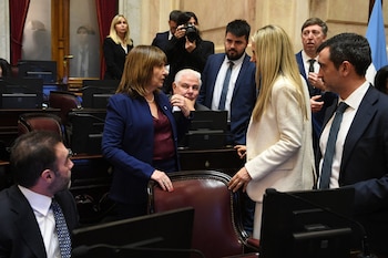 Vista elevada de un recinto legislativo semicircular con personas sentadas en bancas frente a computadoras y pantallas electrónicas