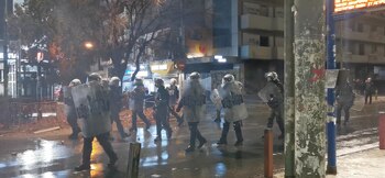 Agentes de policía caminan durante los enfrentamientos tras el accidente en el que chocaron dos trenes cerca de la ciudad de Larissa, en Atenas, Grecia, el 2 de marzo de 2023, en esta imagen fija obtenida de un vídeo en las redes sociales. @atesaltinda/via REUTERS