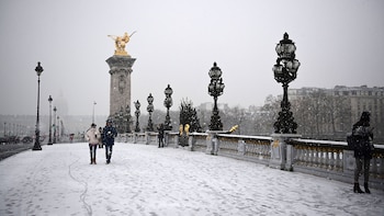 Parisinos caminan por el puente