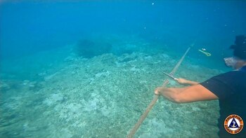 Un buzo cortando una cuerda