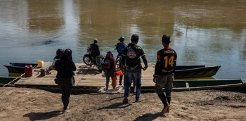 Personas cruzando el río Tarra