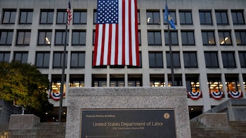 Edificio Frances Perkins del Departamento de Trabajo de EE. UU. en Washington, con una bandera americana vertical y un letrero identificativo en primer plano