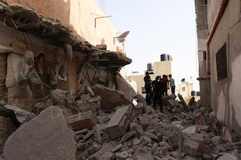 Imagen de archivo de palestinos entre los escombros de una casa destruida tras un ataque aéreo israelí en el campo de refugiados de Yenin (EFE/EPA/ALAA BADARNEH)