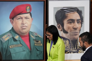 La presidenta encargada Delcy Rodríguez pasa ante imágenes de Hugo Chávez y Simón Bolívar en la Asamblea Nacional de Caracas, el 15 de enero de 2026, días después de la captura de Nicolás Maduro por parte de Estados Unidos. (AP Foto/Ariana Cubillos, archivo)
