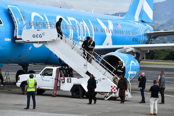 Migrantes deportados de Estados Unidos bajan de un avión en la pista del Aeropuerto Internacional Juan Santamaría en Alajuela, Costa Rica, el 11 de abril de 2026. (Ezequiel BECERRA / AFP)